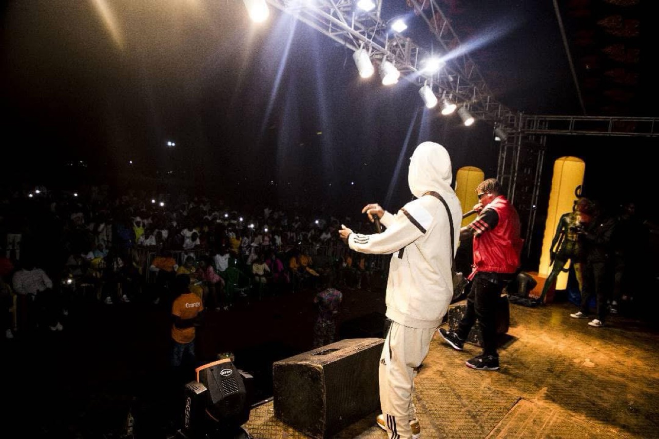Concert de nuit : Le Mélangeur en tenue blanche sur scène, face à une immense foule